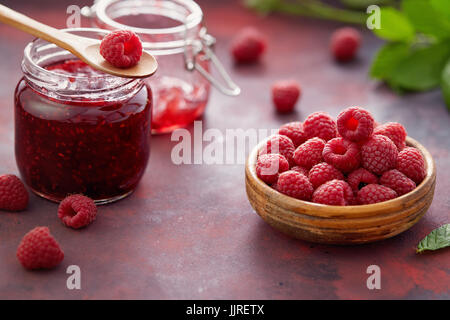 Framboises fraîches et un pot de confiture de framboises. Banque D'Images