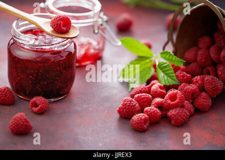 Framboises fraîches et un pot de confiture de framboises. Banque D'Images