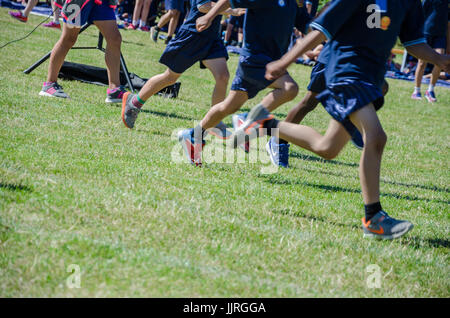 Les jambes des enfants en compétition dans une course à l'école sports le jour. Banque D'Images