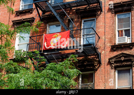 Or, rouge et blanc United States Marine Corps drapeau sur une issue de secours dans un immeuble de Manhattan à New York City Banque D'Images