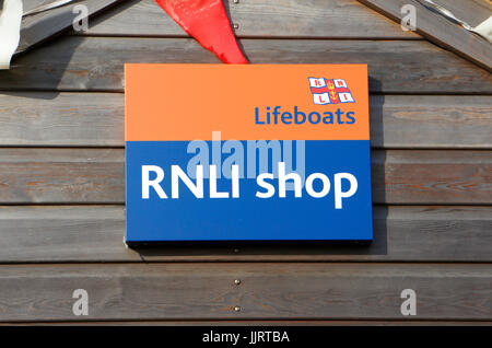 Boutique de la RNLI signe par le poste de recherche et sauvetage au panier gap road, happisburgh, Norfolk, Angleterre, Royaume-Uni. Banque D'Images