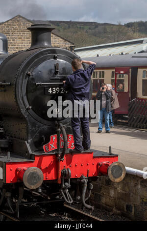 Conducteur de train à l'avant de la locomotive à vapeur, BR (Midland Railway) 4F 0-6-0, arrêté à 43924 station - Keighley et vaut Valley Railway, England, UK. Banque D'Images