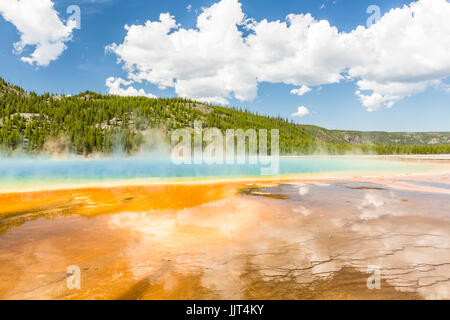 Les nuages reflètent dans les couleurs arc-en-ciel vif du Grand Prismatic Spring dans le Parc National de Yellowstone, Wyoming Banque D'Images