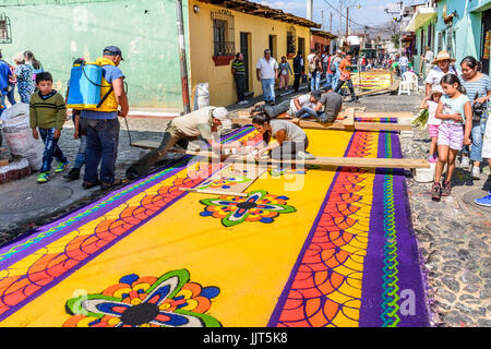 Antigua, Guatemala - mars 26, 2017 : les habitants de la sciure teints faire procession carême tapis dans petite ville coloniale avec des célébrations de la semaine sainte Banque D'Images