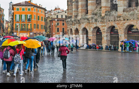 Vérone ITALIE UN JOUR DE PLUIE À L'ARÈNE D'UN GROUPE DE TOURISTES AVEC DES PARAPLUIES colorés Banque D'Images