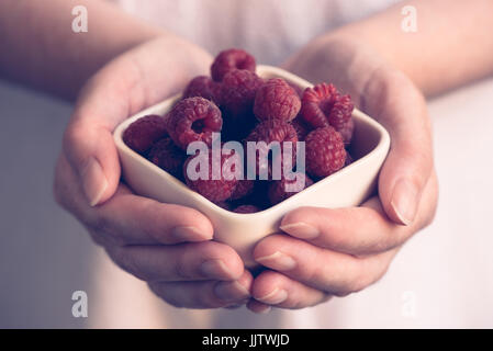 De la vaisselle avec des framboises dans femme mains, selective focus Banque D'Images