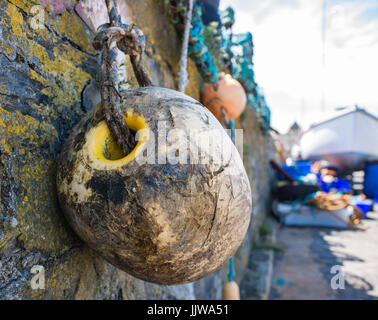 Bouée de pêche ancien suspendre à un mur dans le port de Port St Mary Banque D'Images