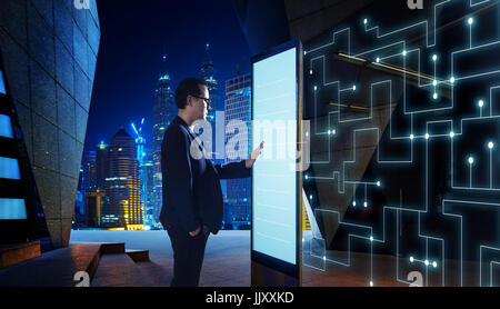 Smart businessman de toucher l'écran pour rechercher l'information de réseau de communication intelligente des choses . Scène de nuit avec l'arrière-plan la ville moderne Banque D'Images