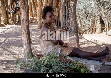 Damara femme assise à l'ombre avec joues peintes au Musée Vivant Damara, Namibie, Afrique. Banque D'Images