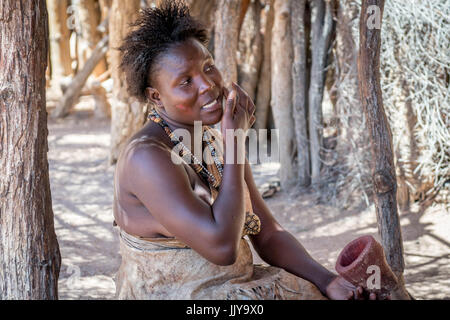 Damara femme assise à l'ombre des joues à la peinture Musée Vivant Damara, Namibie, Afrique. Banque D'Images