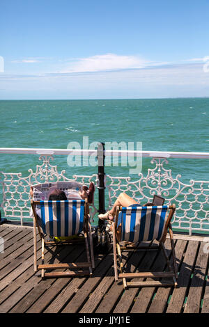 Brighton, UK. 21 juillet, 2017. Journée chaude sur Brighton. Couple de soleil sur des chaises longues sur la jetée de Brighton. Crédit : Rob Carter/Alamy Live News Banque D'Images