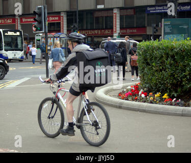 Jeune homme garçon Cycliste Vélo de livraison Livraison La livraison en dehors de l'alimentation Uber sur street road Banque D'Images