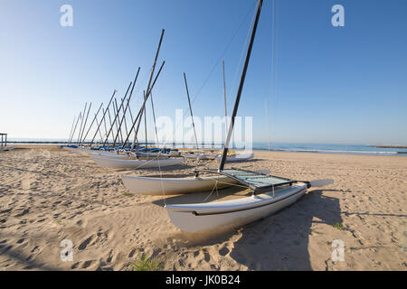 Groupe de bateaux catamaran dans la rangée sur la plage Els Terrers, à Benicassim, Castellon, Valencia, Espagne, Europe. Clair bleu ciel et mer Méditerranée Banque D'Images