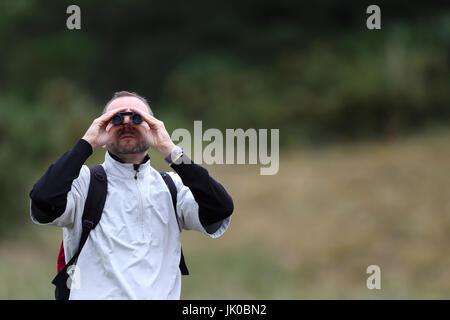 Un spectateur regarde l'action dans les jumelles au cours de la deuxième journée de l'Open Championship 2017 à Royal Birkdale Golf Club, Southport. Banque D'Images