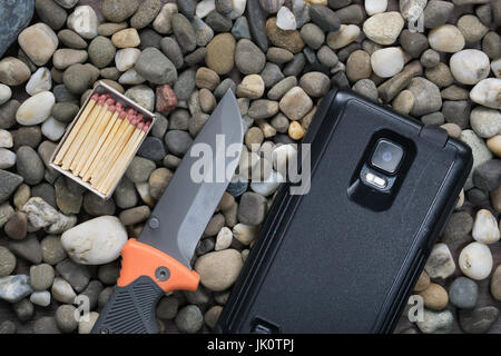 De nos jours la trousse de survie moderne. fort avec des allumettes, couteau pliant et robuste sur les rochers. smartphone dure toujours rester connecté Banque D'Images