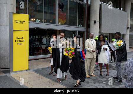 Les diplômés dame fling leurs chapeaux mortier loués dans l'air après leur graduation eremony, pour célébrer leurs réalisations universitaires, l'université à l'extérieur de la salle des fêtes, le 20 juillet 2017, sur la Southbank, Londres, Angleterre. Banque D'Images