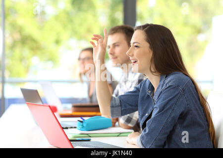 Vue latérale d'une sensibilisation des étudiants assis bras dans une classe avec des camarades à l'arrière-plan Banque D'Images