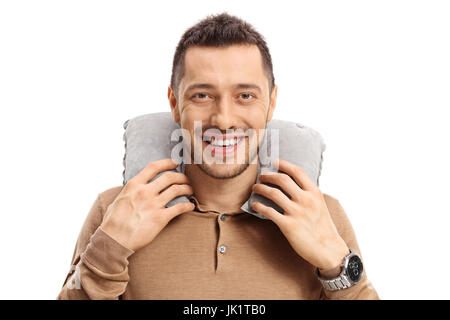 Jeune homme avec un oreiller de cou regardant la caméra et smiling isolé sur fond blanc Banque D'Images