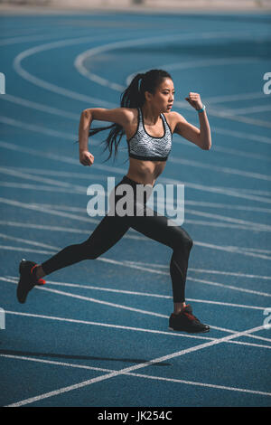 Formation sportive asiatique sur une piste de course, stade jeune fille courir concept Banque D'Images