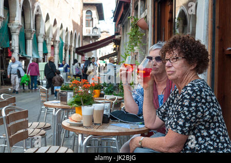 Deux femmes boire un Spritz, une boisson alcoolisée traditionnelle à Venise, Italie Banque D'Images