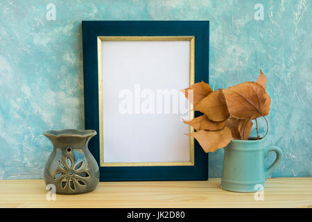 Cadre doré bleu et immersive, mur en béton, bois, table, feuilles d'alevins d'aromathérapie, lampe, automne, automne, tranquillité, détente Banque D'Images