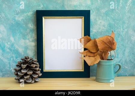 Maquette du châssis de l'automne, bleu et golden border, branche d'arbre avec des feuilles sèches en emplacements, cône de pin, mur en béton, de fond nordique minimaliste rustique sty Banque D'Images