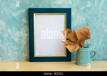 Maquette du châssis de l'automne, bleu et golden border, branche d'arbre avec des feuilles sèches en emplacements, mur de béton bleuâtre, de fond, de style nordique minimaliste rustique Banque D'Images