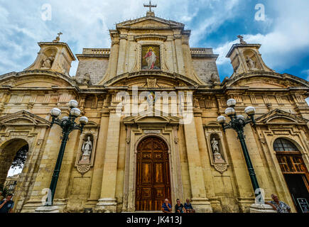 L'église cathédrale gothique ou dans l'ancienne ville de Mdina sur l'île méditerranéenne de Malte auprès des gens assis sur les marches en face Banque D'Images