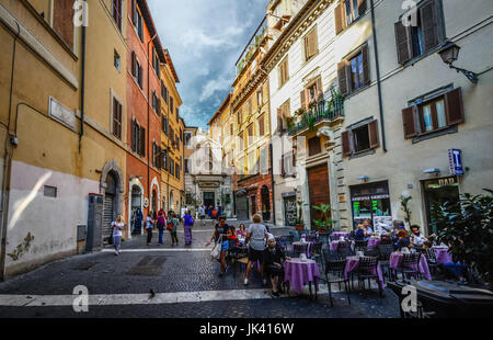 Petit hors de la façon dont la piazza hors des sentiers battus à Rome Italie avec une vieille femme assise seule dans un café tandis que les jeunes italiens, rendez-vous sur la journée Banque D'Images