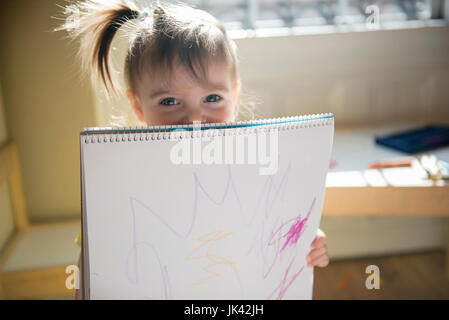 Caucasian baby girl montrant dessin sur sketchpad Banque D'Images