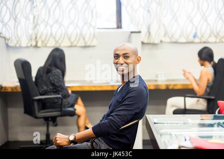 Portrait of smiling African American man sitting in office Banque D'Images