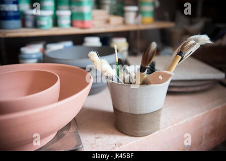 Les brosses et les bols de poterie en atelier Banque D'Images