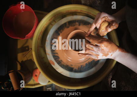 Mains d'Caucasian woman façonner l'argile de poterie sur roue Banque D'Images