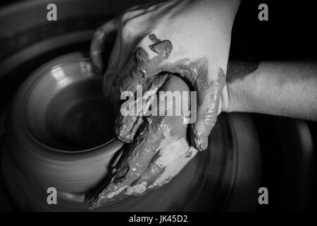 Mains d'Caucasian woman façonner l'argile de poterie sur roue Banque D'Images