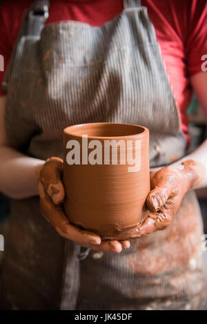Caucasian woman montrant tasse poterie Banque D'Images