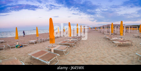 Des chaises longues et des parasols fermés dans une station balnéaire de l'Émilie-Romagne sur la côte Adriatique en Italie, l'atmosphère calme et détendue de l'été Banque D'Images
