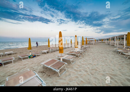 Des chaises longues et des parasols fermés dans une station balnéaire de l'Émilie-Romagne sur la côte Adriatique en Italie, l'atmosphère calme et détendue de l'été Banque D'Images