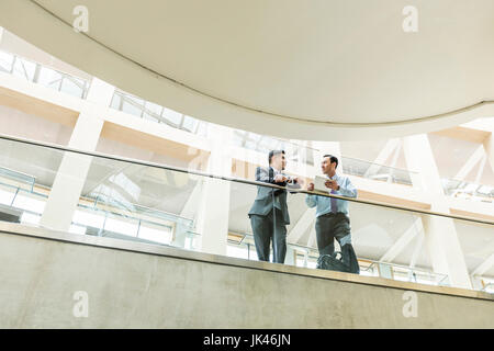 Mixed Race woman using digital tablet in lobby Banque D'Images