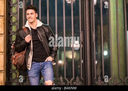 Sac de transport Smiling Caucasian man leaning on gate Banque D'Images