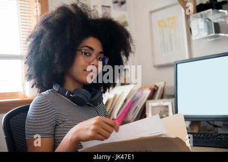 Certain African American Woman holding files près de l'ordinateur Banque D'Images