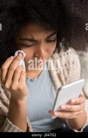 African American Woman crying et texting on cell phone Banque D'Images