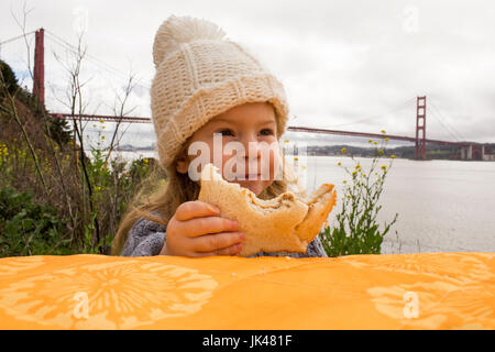 Young Girl eating sandwich en plein air Banque D'Images