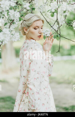 Middle Eastern woman smelling flowers on tree Banque D'Images