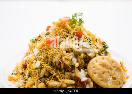 Bhel Puri - Mumbai populaires street servi avec de la coriandre et du chutney de tamarin sur fond blanc, selective focus Banque D'Images