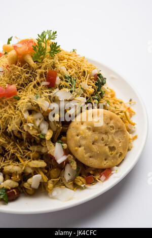 Bhel Puri - Mumbai populaires street servi avec de la coriandre et du chutney de tamarin sur fond blanc, selective focus Banque D'Images