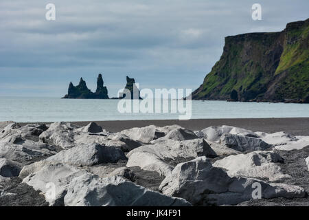 Plage de sable noir Reynisfjara qui jouit et les roches près de Vik, ville de jour d'Islande par temps couvert Banque D'Images