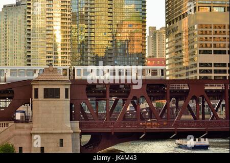 Le soleil qui crée des reflets sur une variété de bâtiments comme un LTC du train traverse la rivière Chicago. Chicago, Illinois, USA. Banque D'Images