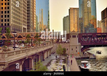 Comme le soleil qui crée reflecitons Chicagl sur une variété de surfaces de construction, une ligne Brune CTA du train traverse la rivière Chicago. Banque D'Images