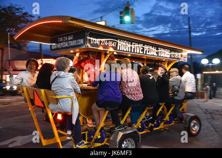 Cinq tours de pédale forte avec les passagers de la bicyclette à travers les rues du centre-ville d'Ann Arbor, Michigan sur une soirée à la fin du printemps. L'alcool, la socialisation. Banque D'Images