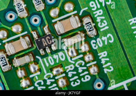 Composants de la technologie de montage en surface (CMS) sur une carte de circuit imprimé verte. Câblage à l'intérieur du calculateur, gros plan du circuit, détail d'une carte de circuit imprimé. Banque D'Images
